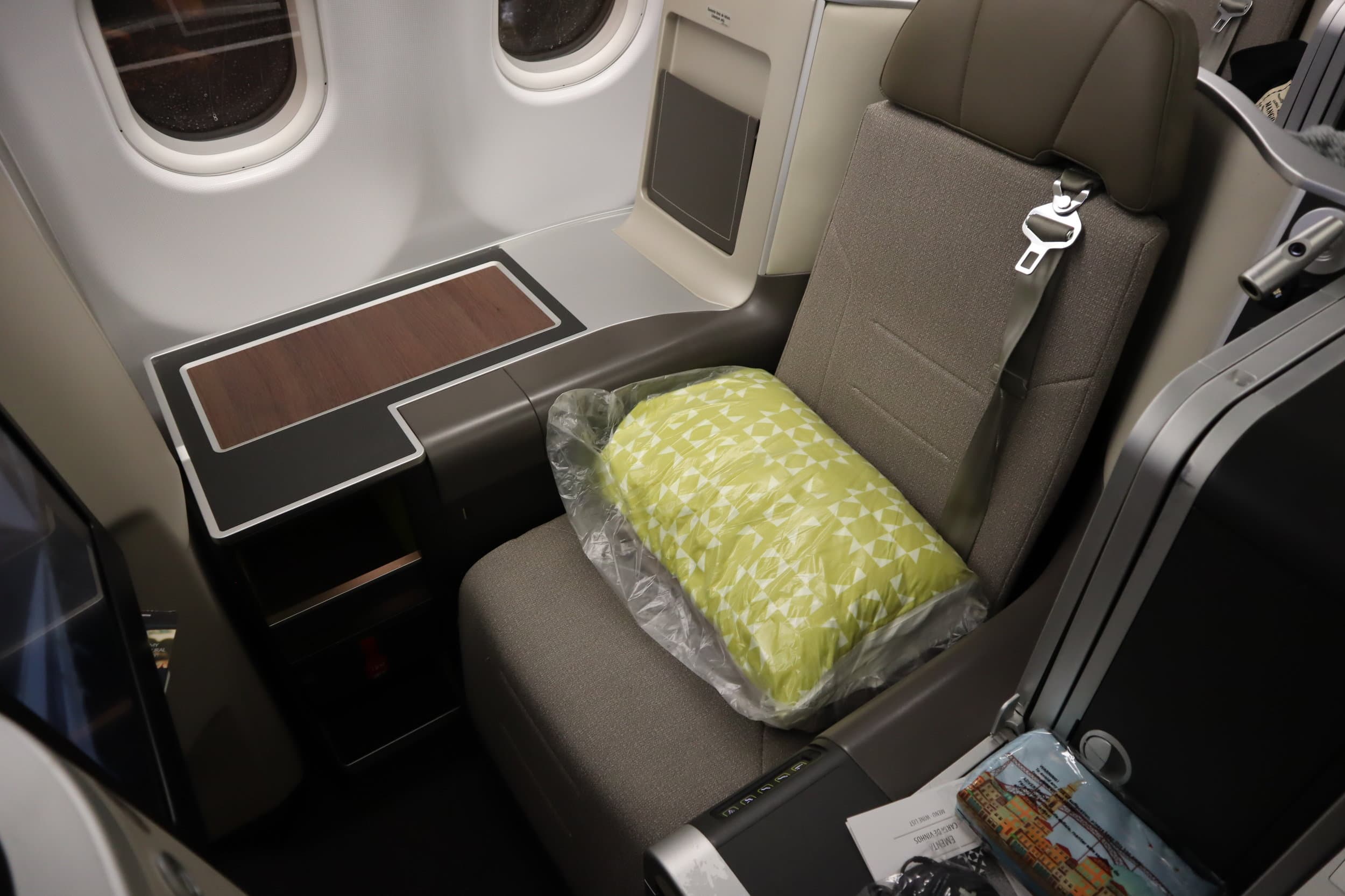 TAP Air Portugal business class seat with blanket and wood-accented console on the A330neo
