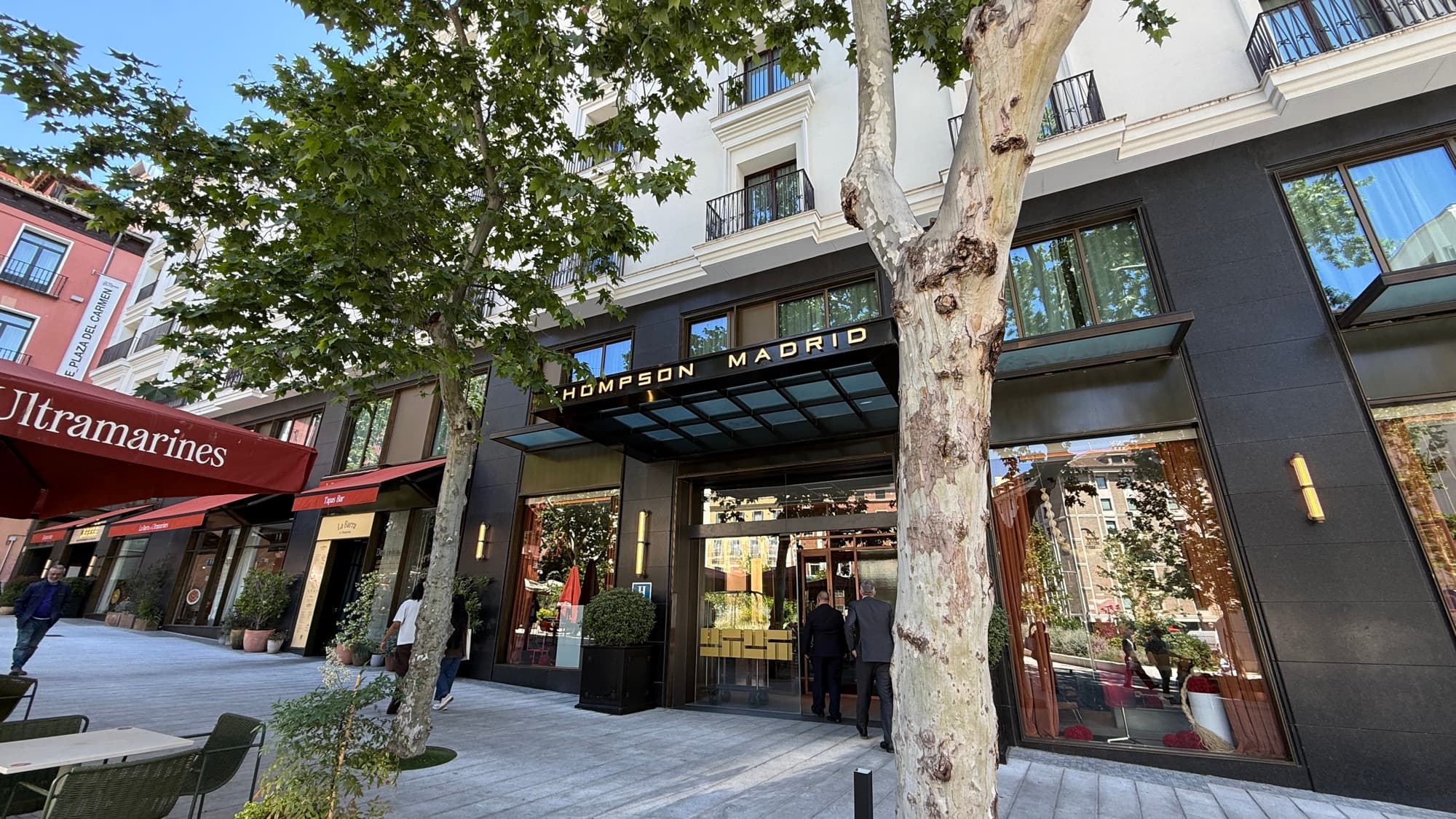 The Thompson Madrid entrance on Plaza del Carmen, framed by plane trees