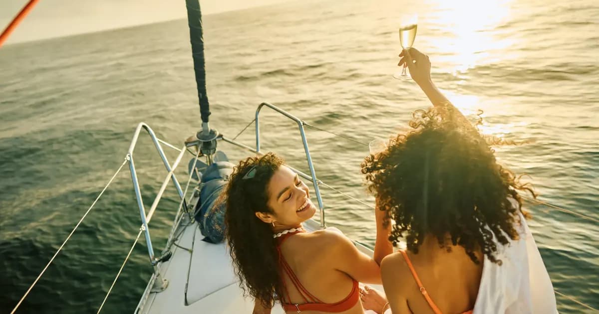 Chexy Win First Class contest, two travellers with champagne on a sailboat at sunset
