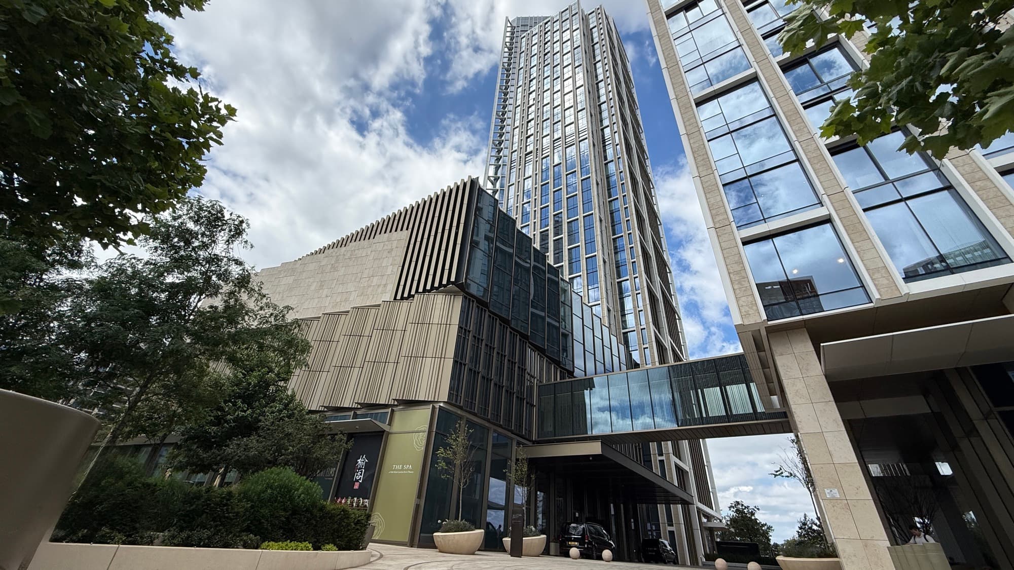 Exterior of the Park Hyatt London River Thames tower in Nine Elms, seen from street level with trees in the foreground