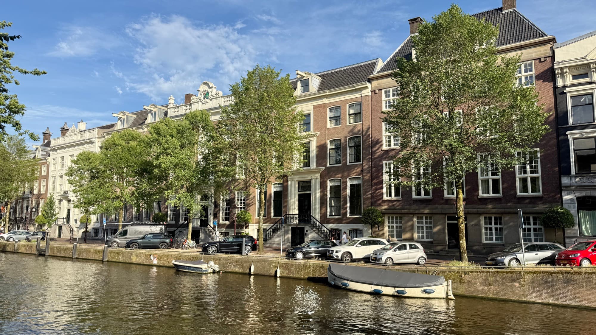 Canal view of the Waldorf Astoria Amsterdam's row of 17th- and 18th-century palaces along the Herengracht, with boats on the water