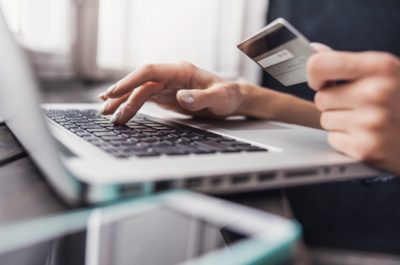 person holding amex near laptop